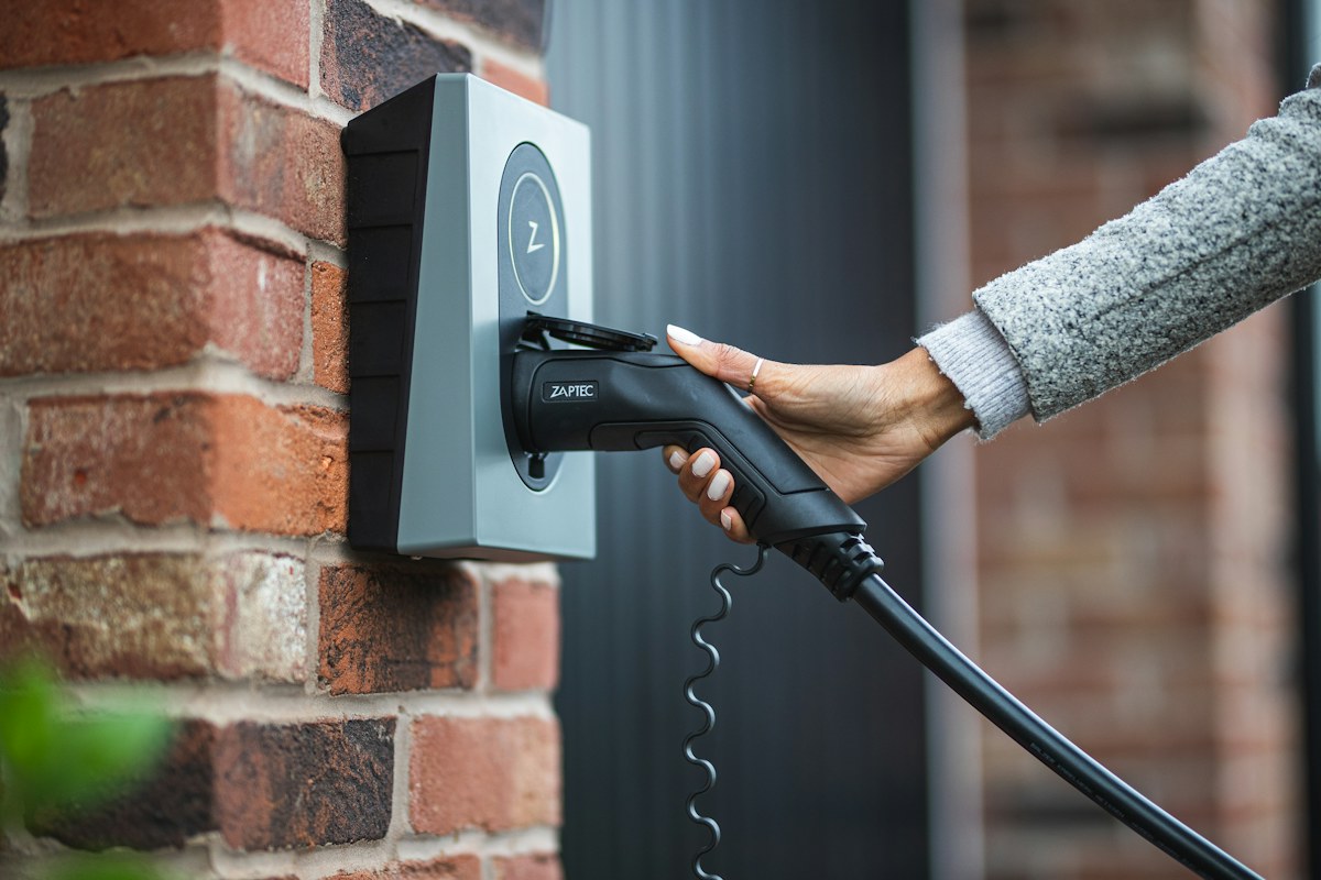 Plugging in an electric car at a wall-mounted home charger